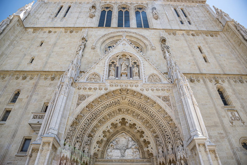 Gothic cathedral facade in Zagreb with intricate stone carvings and statues.